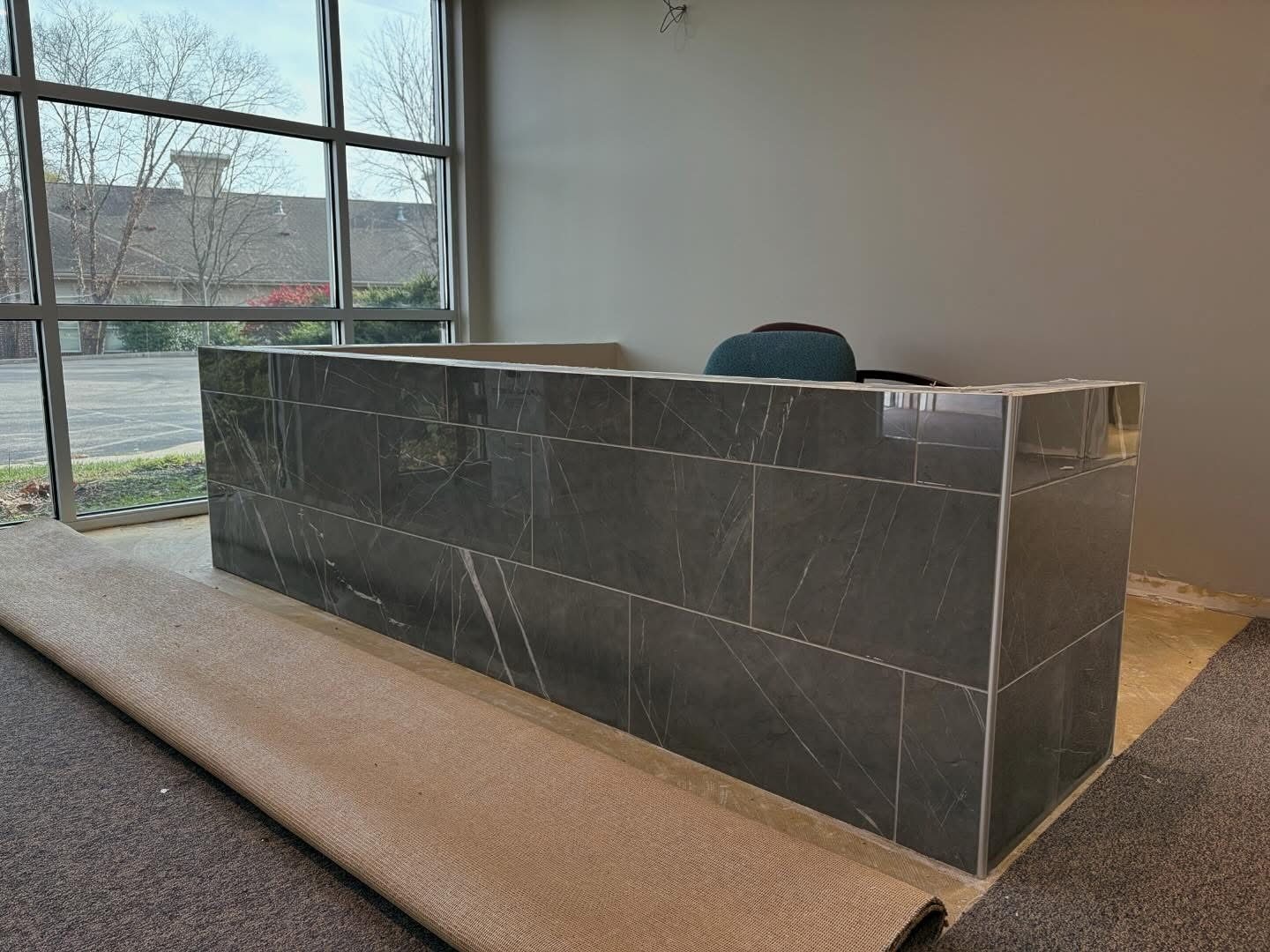 Marble-look tile wrapping a commercial reception desk installed in Dayton, OH