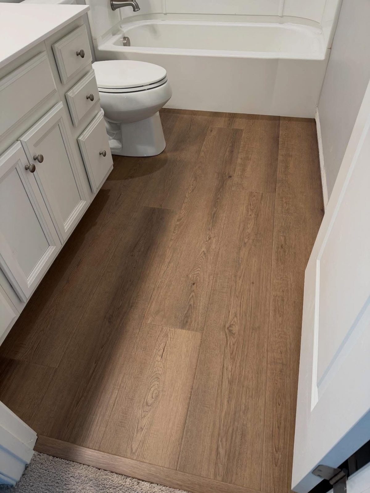 Waterproof LVP flooring installed in a Dayton, OH bathroom around the tub and vanity