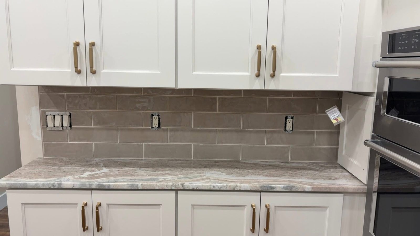 Gray subway tile backsplash with white shaker cabinets